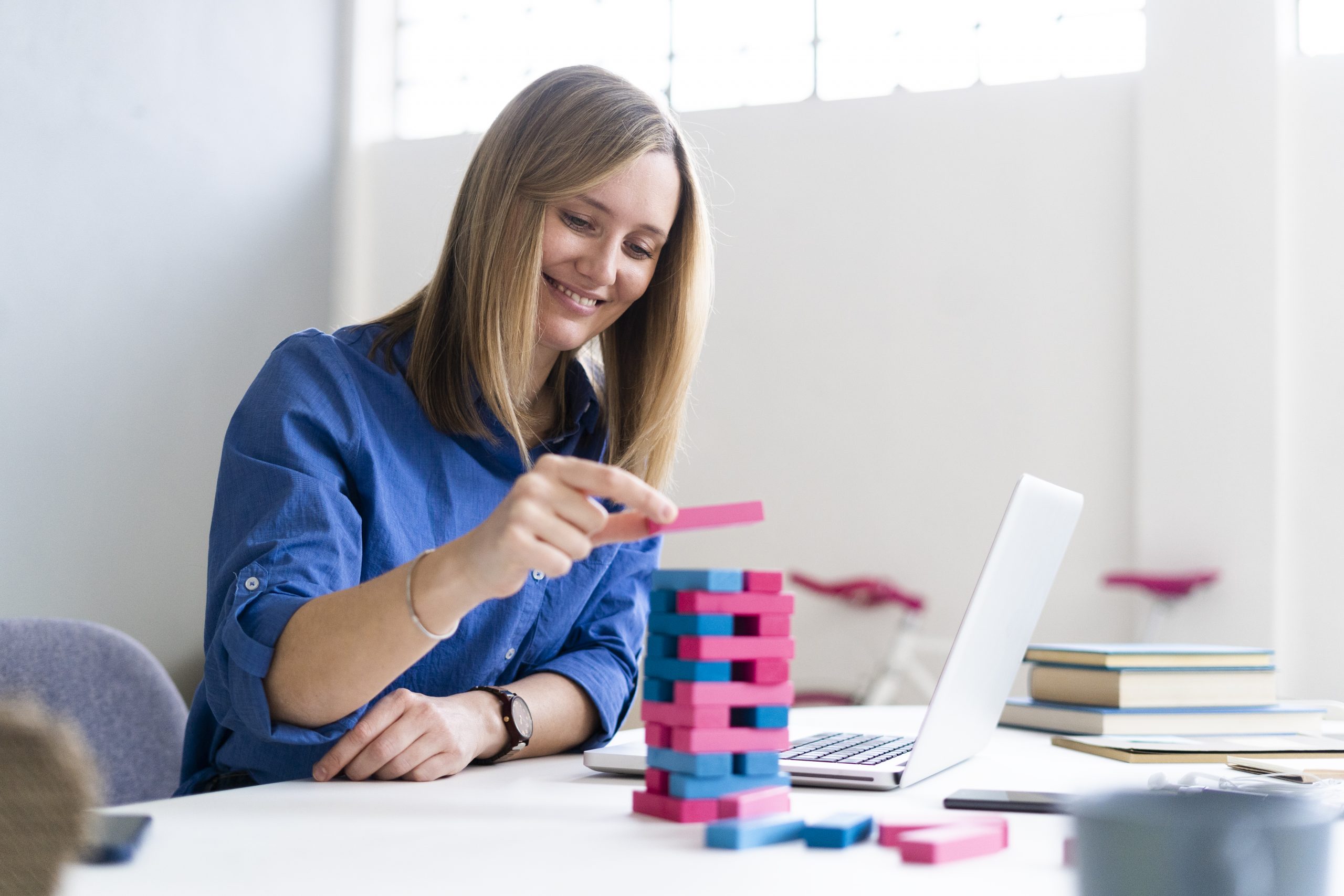 Smiling businesswoman playing block removal game at office