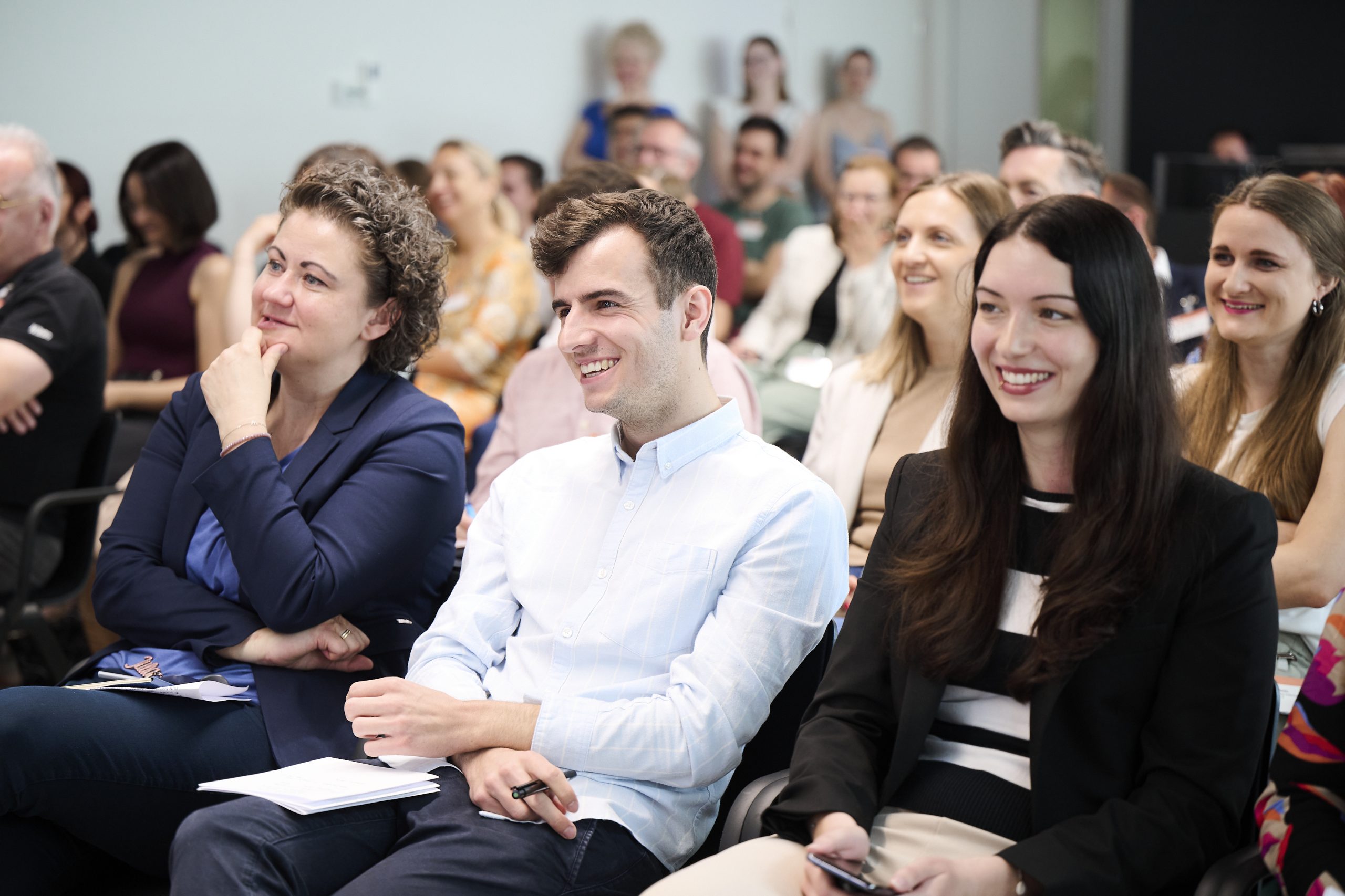Podiumsteilnehmer lachen in die Kamera