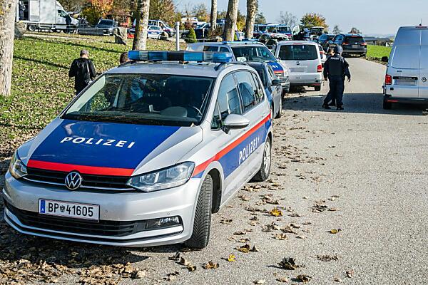 Auf dem Bild sieht man mehrere Polizeautos und Polizisten in ländlicher Umgebung.