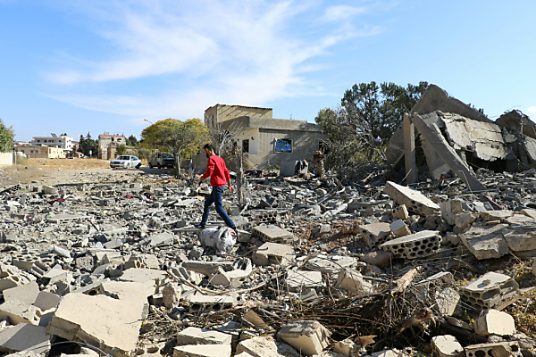 Auf dem Bild sieht man einen Mann in den Trümmern von einem zerstörten Haus im Dorf Douris im Libanon.