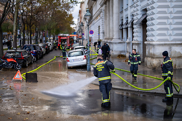 Auf dem Bild sieht man Einsatzkräfte der Feuerwehr, wie sie die überschwemmten und verdreckten Straßen am Wiener Ring reinigen.