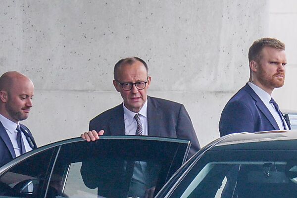 Auf dem Bild sieht man in der Mitte den CDU-Chef Friedrich Merz. Er steigt gerade in ein Auto ein.