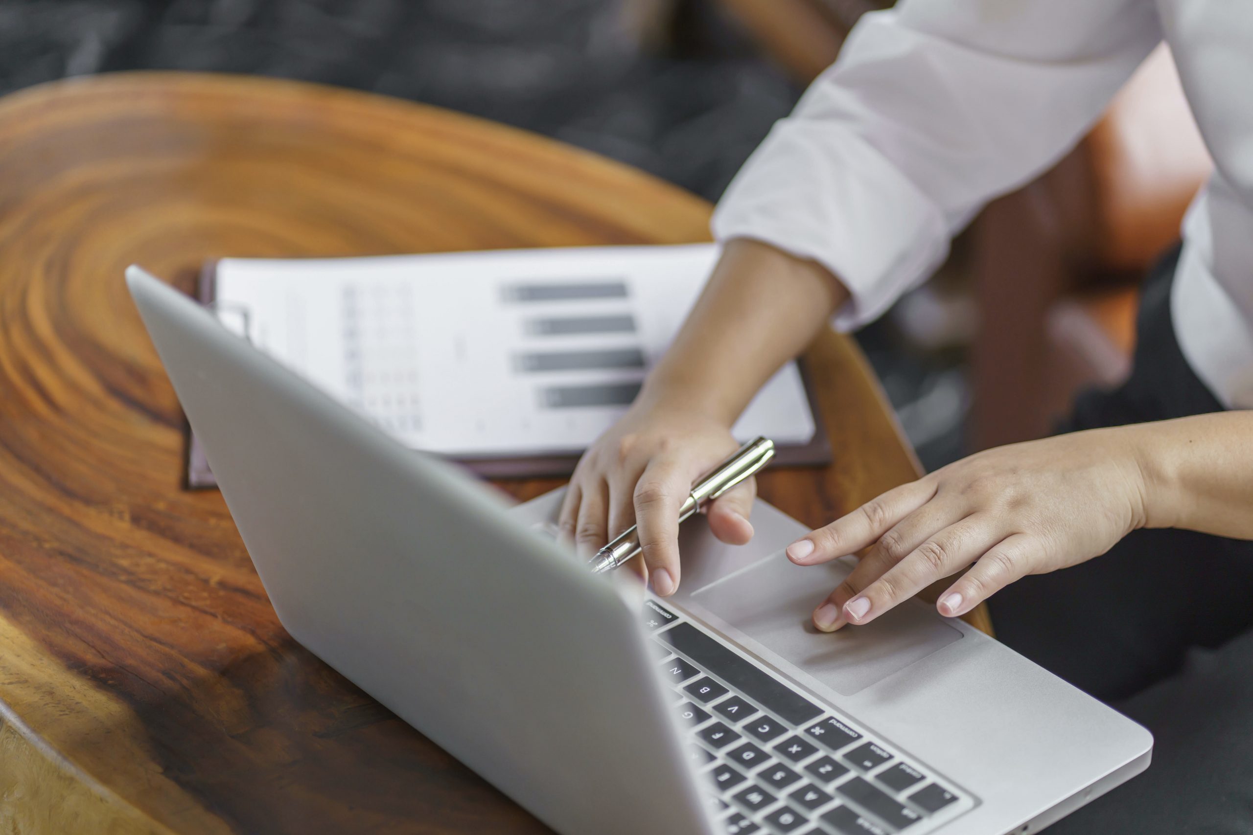 Die Aufnahme zeigt Hänge, die auf einem Laptop tippen