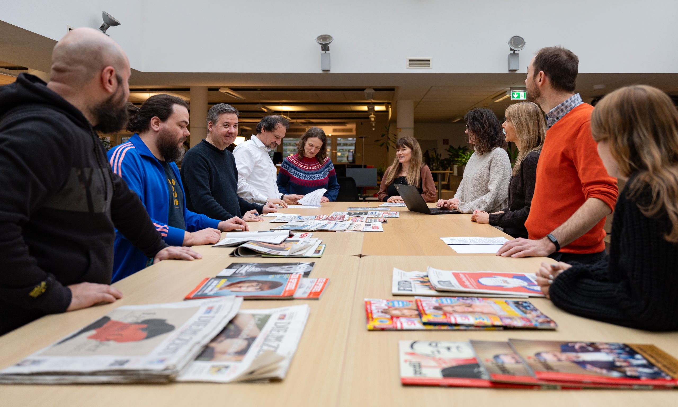 Journalistinnen und Journalisten der APA an einem Besprechungstisch.